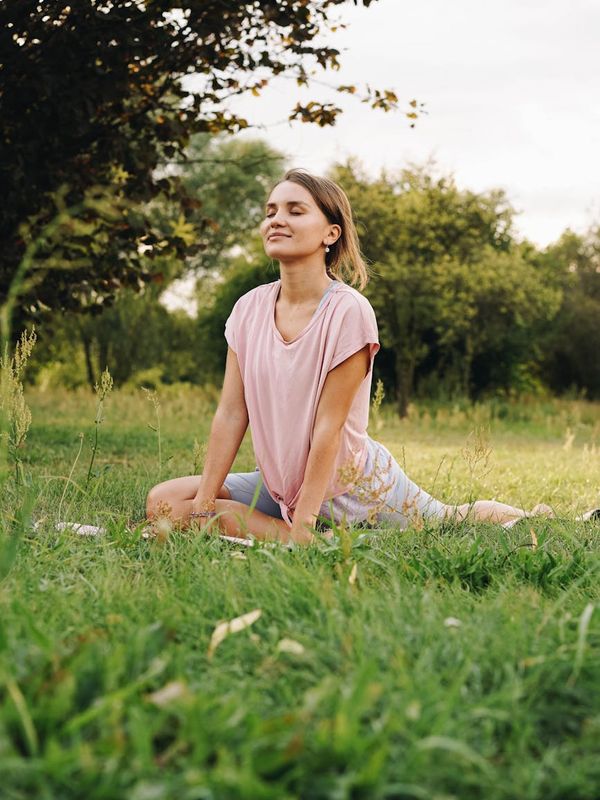 Woman practicing mindful breathing in a calm, sunlit environment.